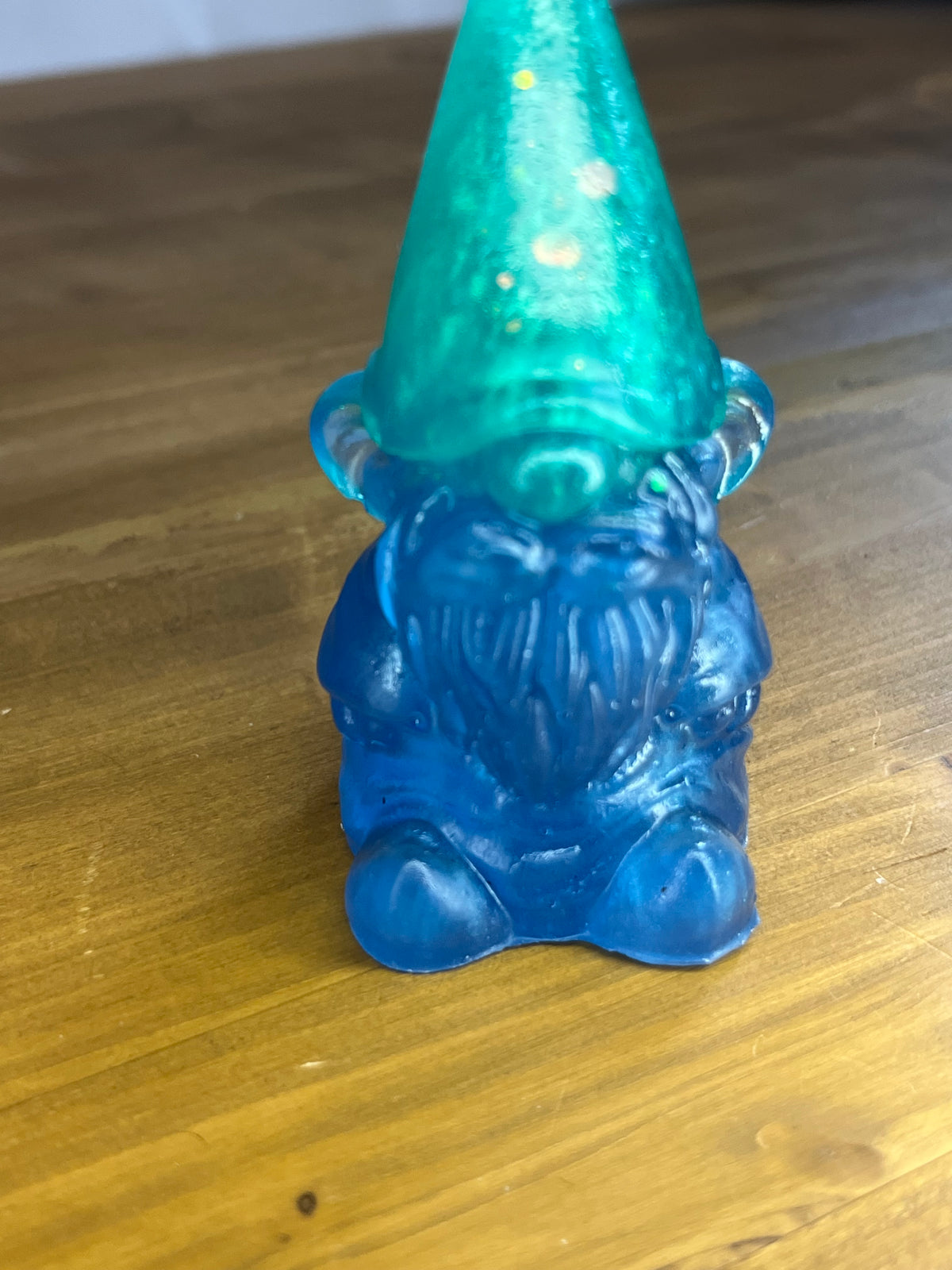 Blue gnome figurine with a green hat on a wooden surface