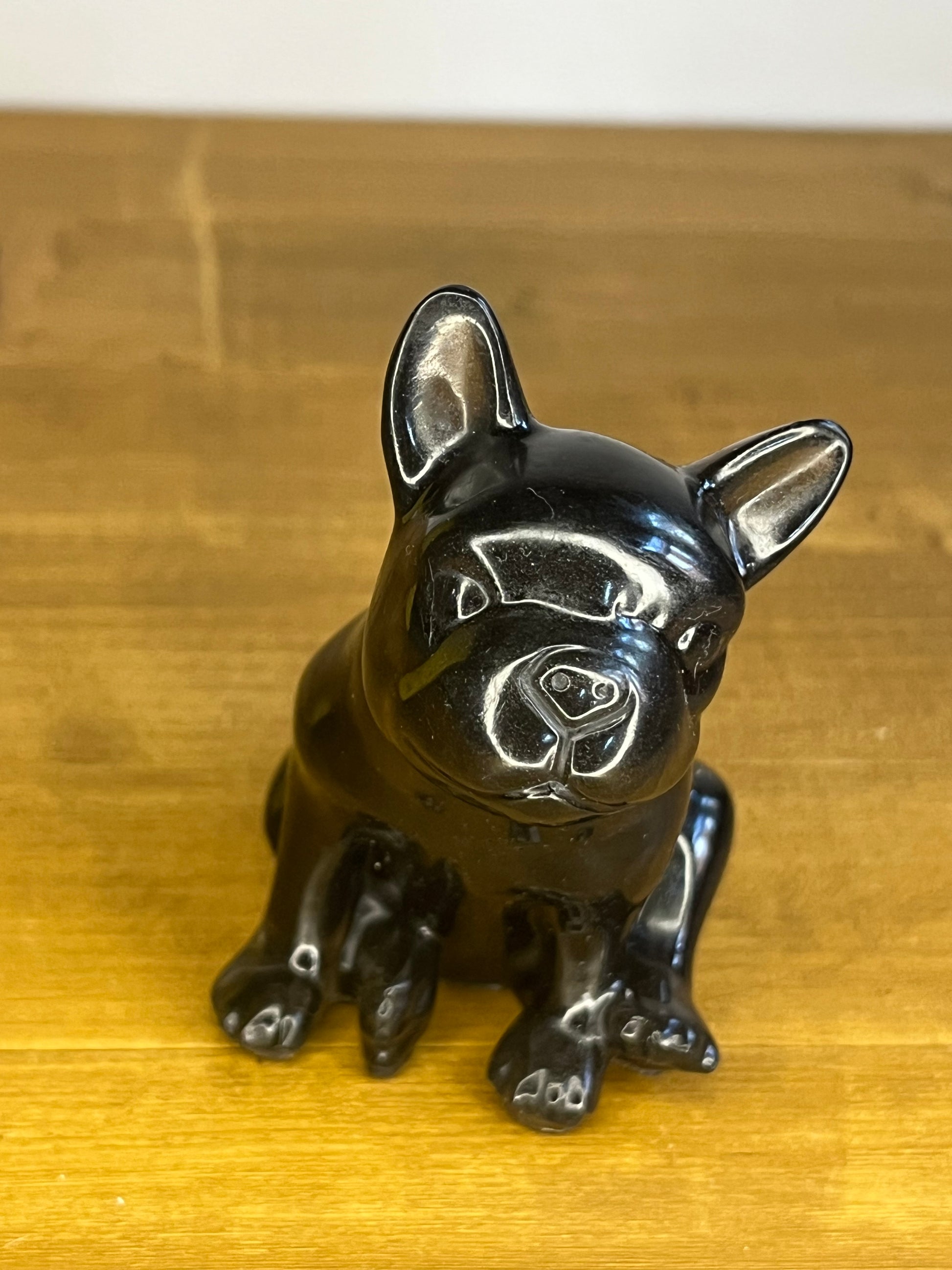 Black resin dog figurine on a wooden surface