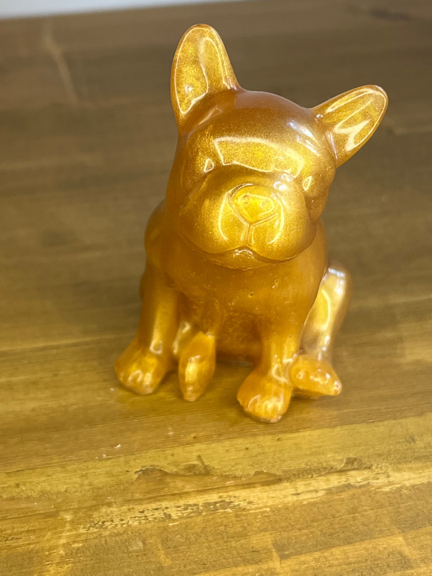 Gold bulldog figurine on a wooden shelf