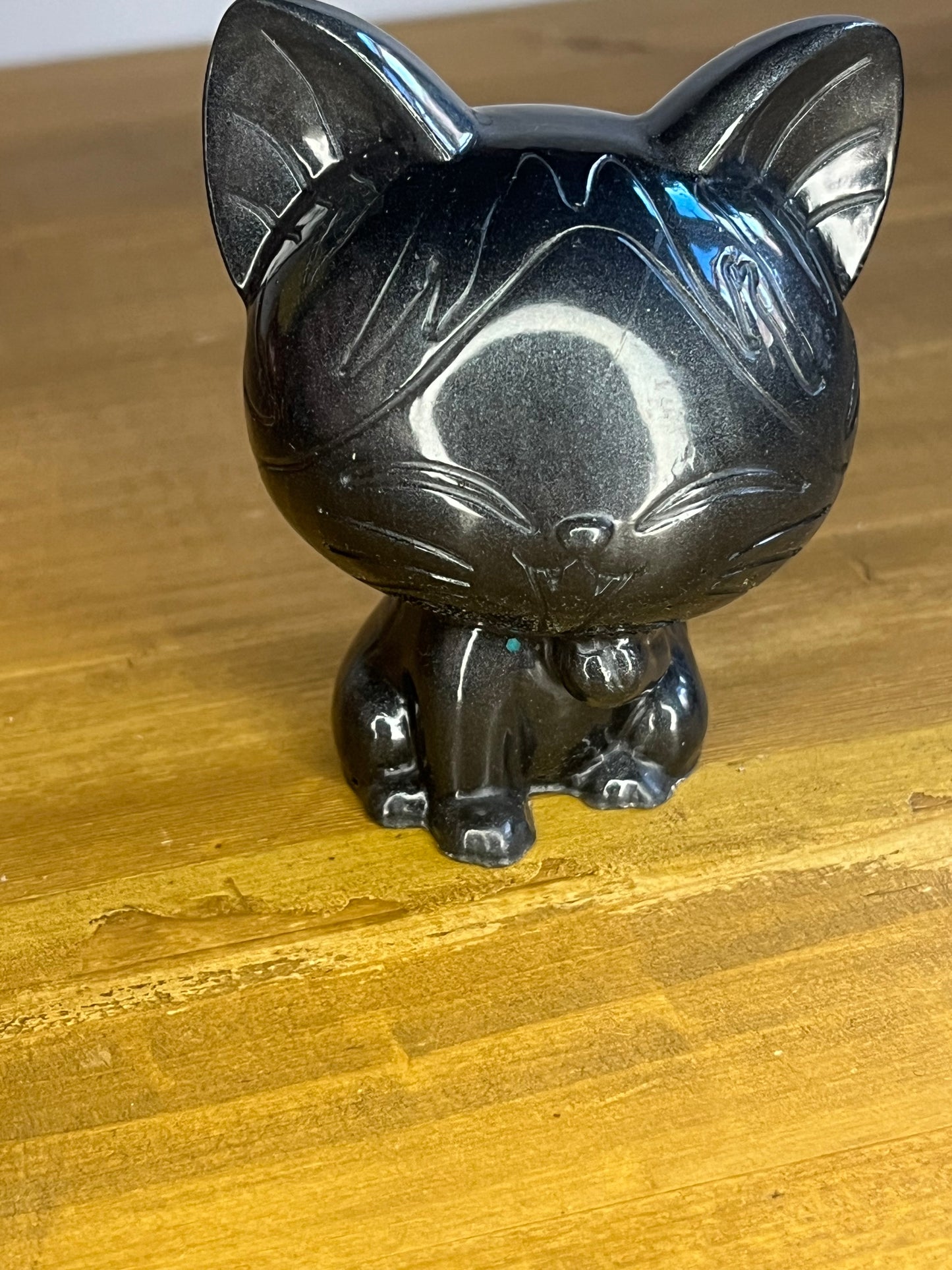 Black cat figurine on a wooden surface