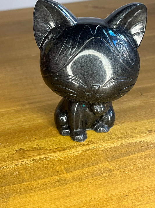 Black cat figurine on a wooden surface
