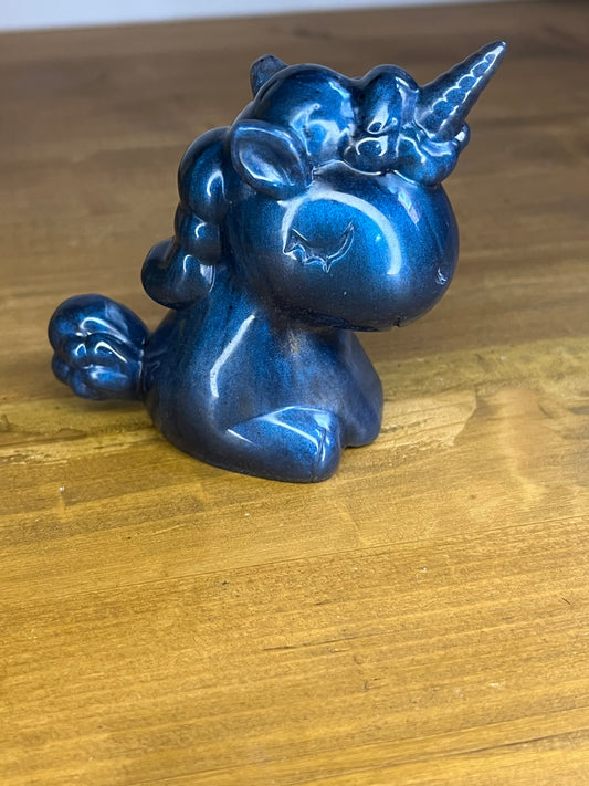 Blue unicorn figurine on a wooden surface