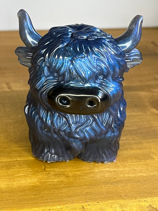 Blue highland cow resin figurine on a wooden shelf
