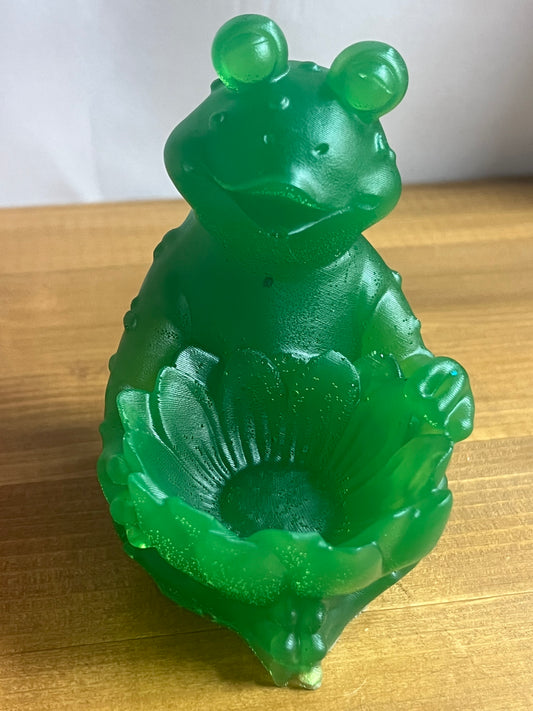 Green jade frog holding a lotus bowl on a wooden surface