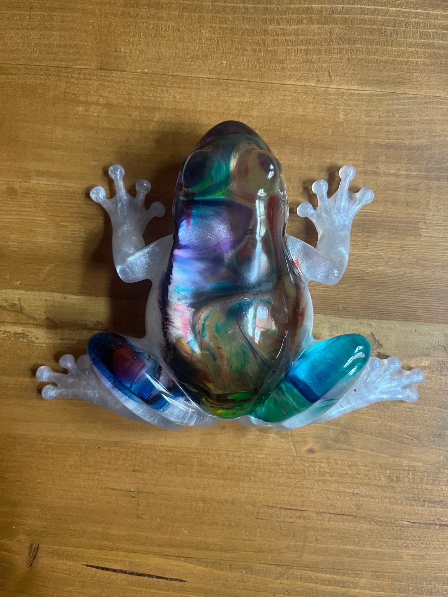 Colorful resin frog on a wooden surface